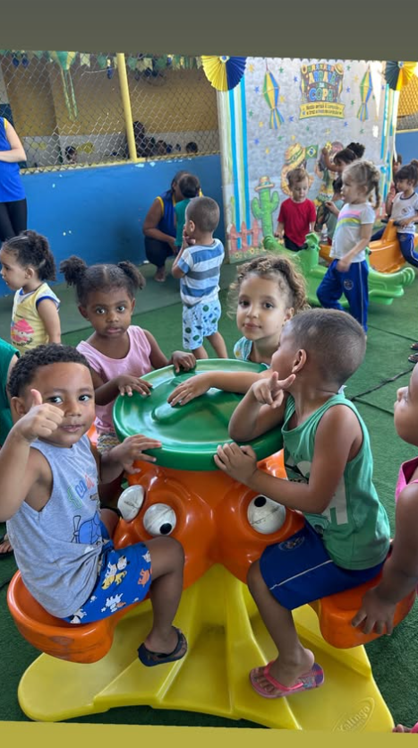 Crianças sorrindo e brincando juntas no parquinho da creche